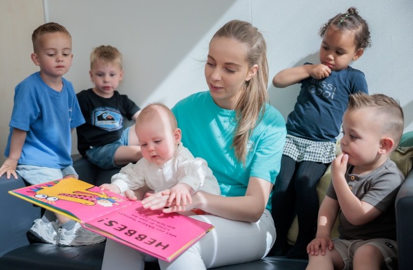 Baby leest boekje op opvang