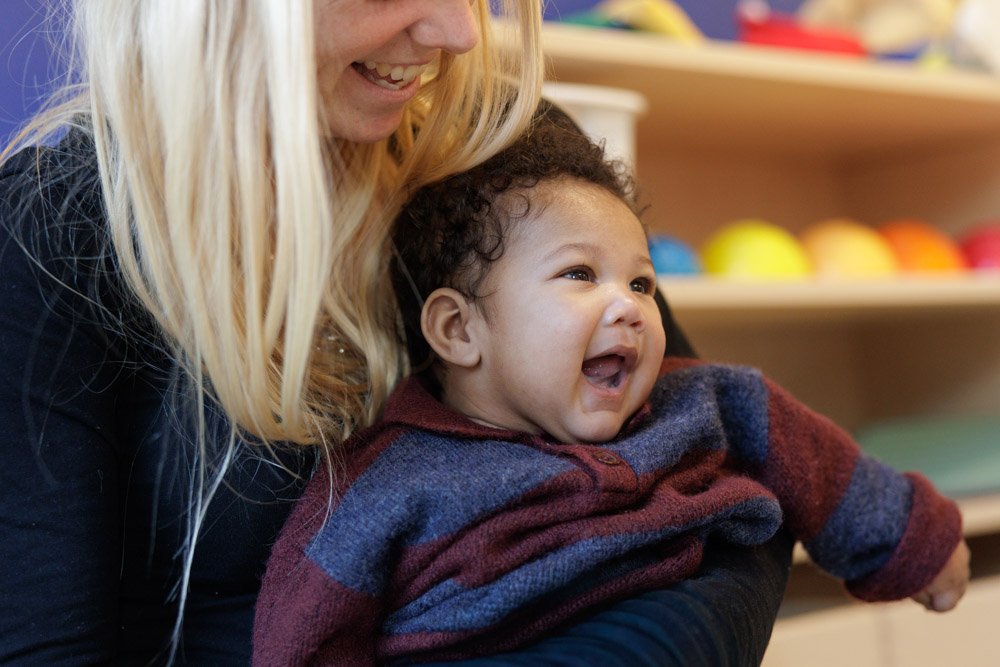 Baby lachend op schoot