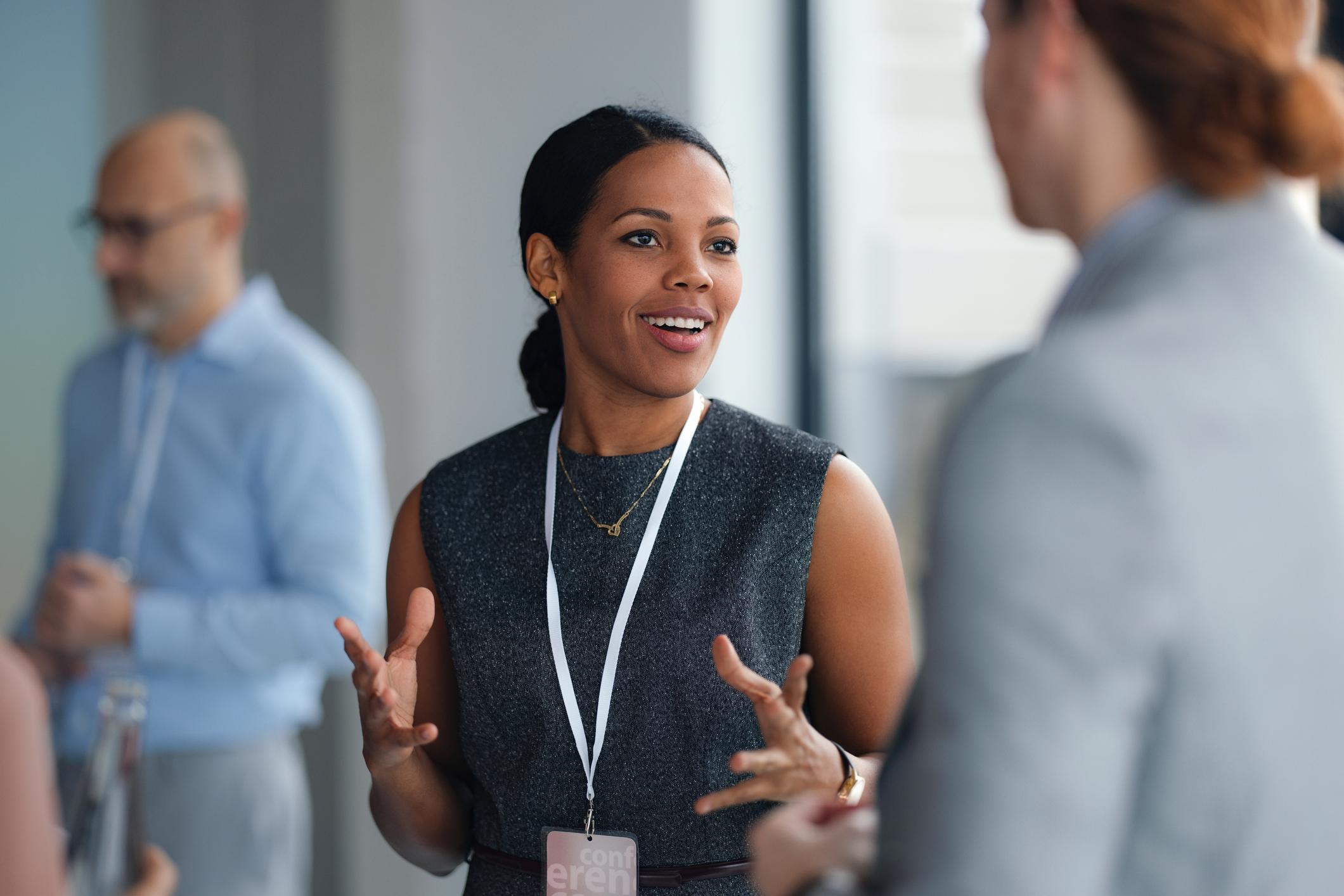 Professional speaking with colleagues at a conference or networking event.
