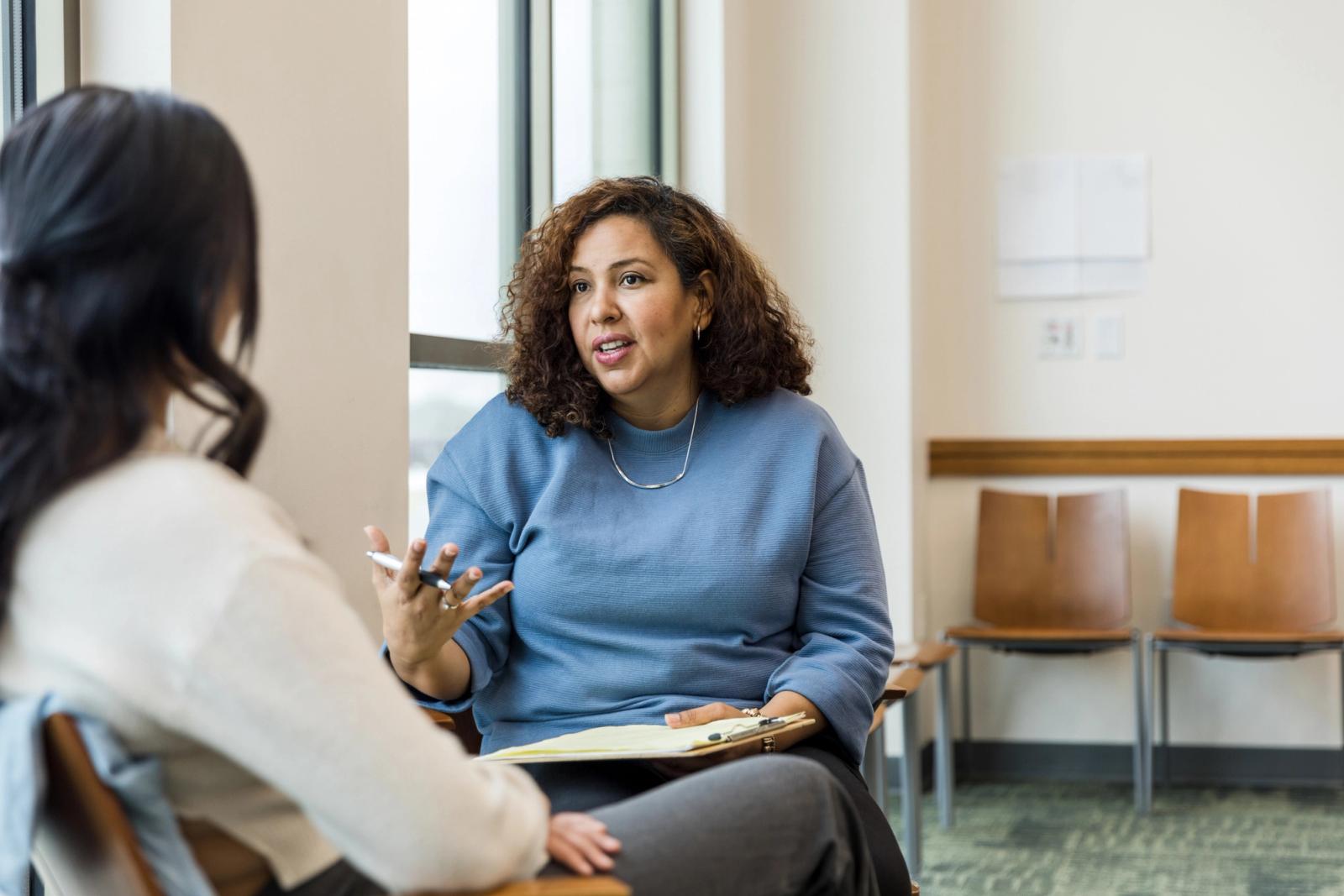 Two women speaking in a behavioral health counseling setting.