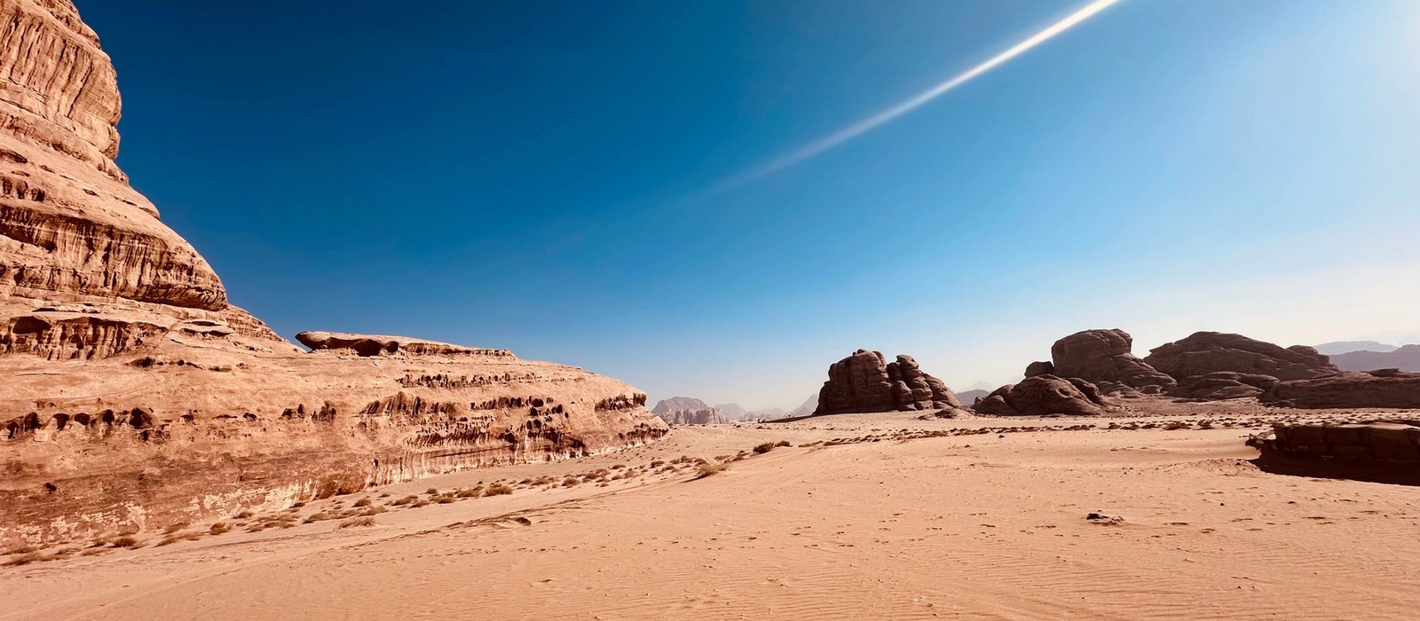 Poušť Wadi Rum v Jordánsku s pískovcovými skalami a modrou oblohou