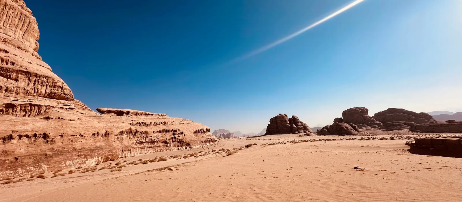 Poušť Wadi Rum v Jordánsku s pískovcovými skalami a modrou oblohou