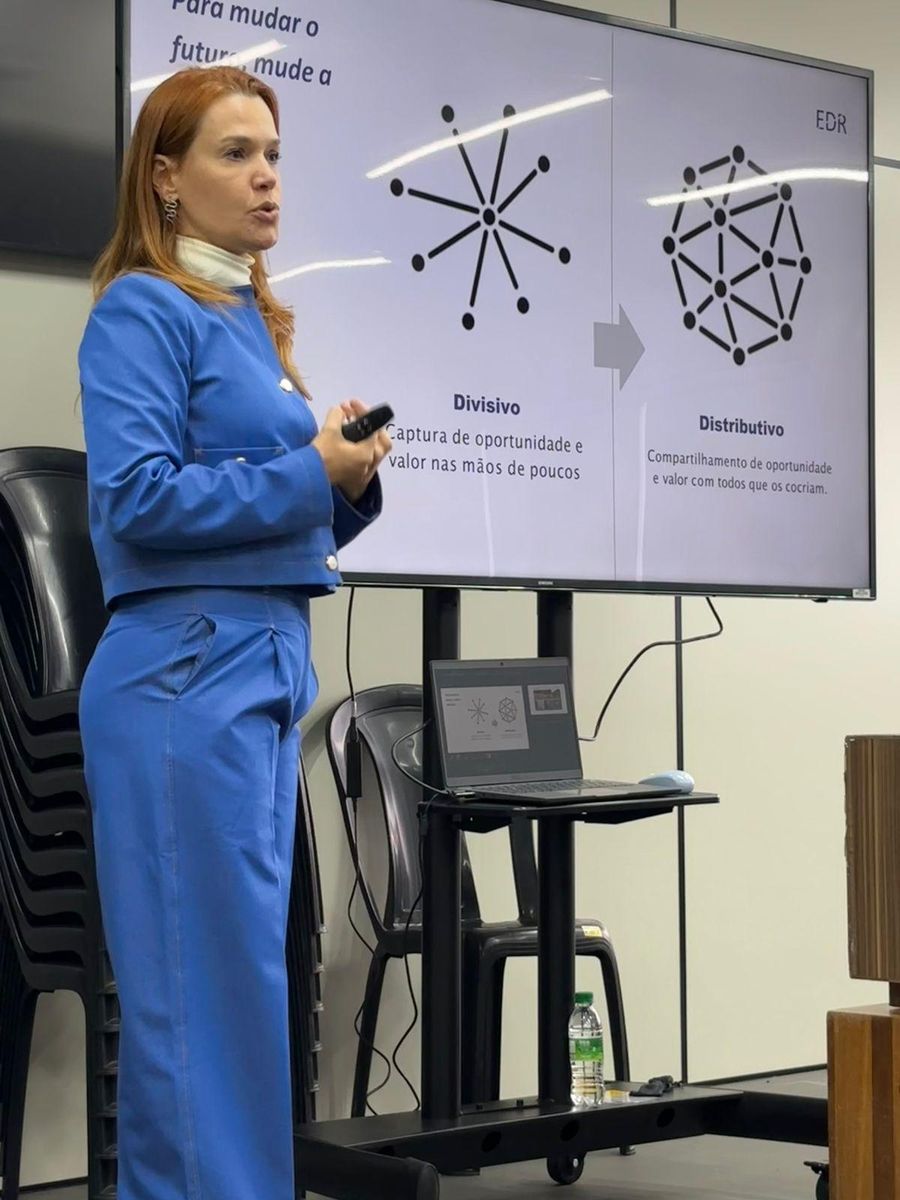 Andrea Eboli apresentando o slide que compara um modelo divisivo e um modelo distributivo de poder