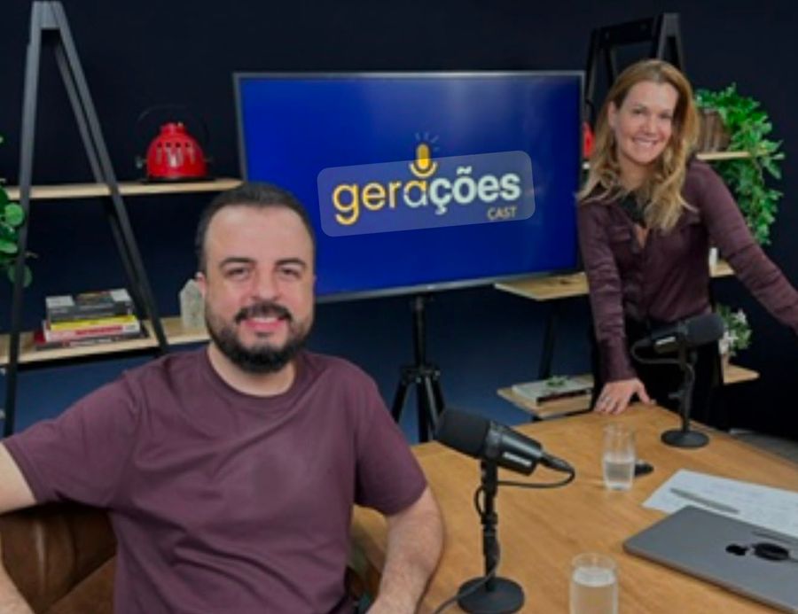 Andrea Eboli em gravação do podcast Gerações Cast, à mesa de estúdio com o apresentador