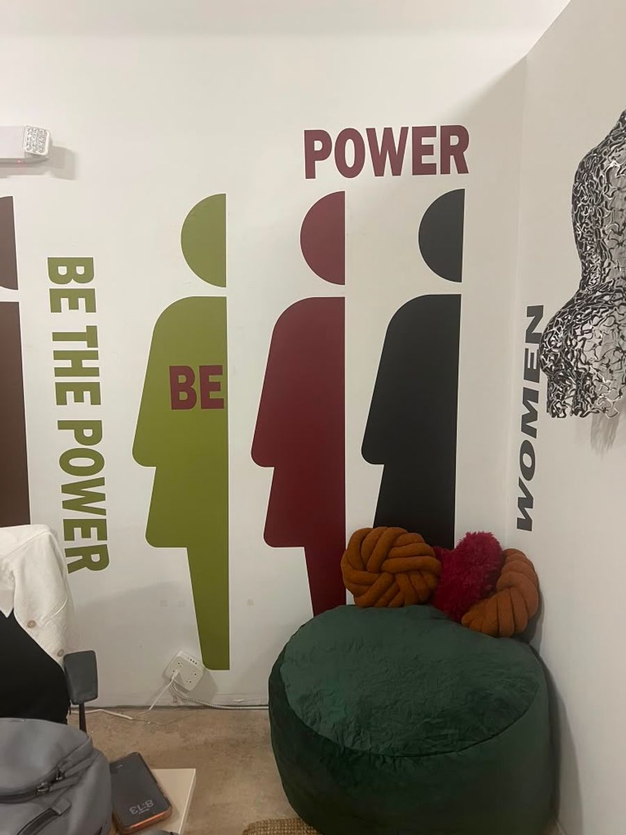 Painel com a arte “Be the Power” em um espaço de evento