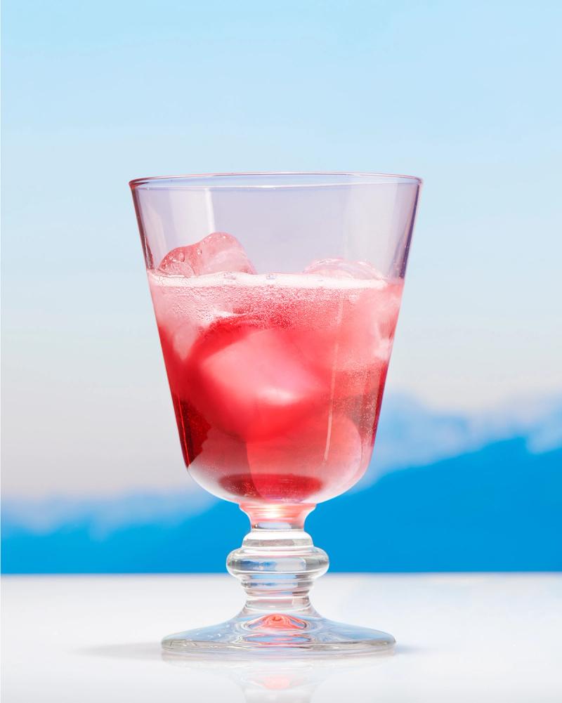 Doladira and soda water in glass with stem with Alps in the background