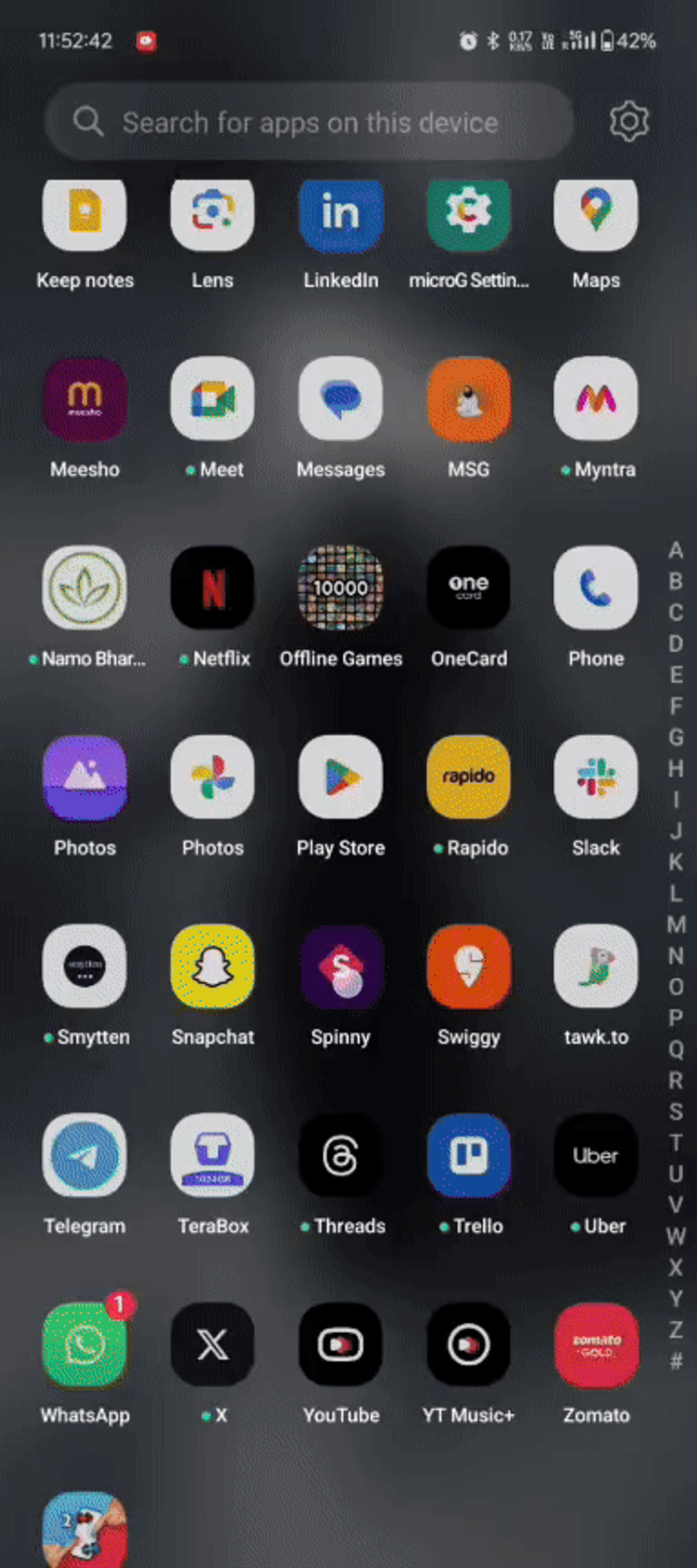 A smartphone screen displaying various app icons like WhatsApp, YouTube, and Uber. The background is dark, and there's a search bar on top.