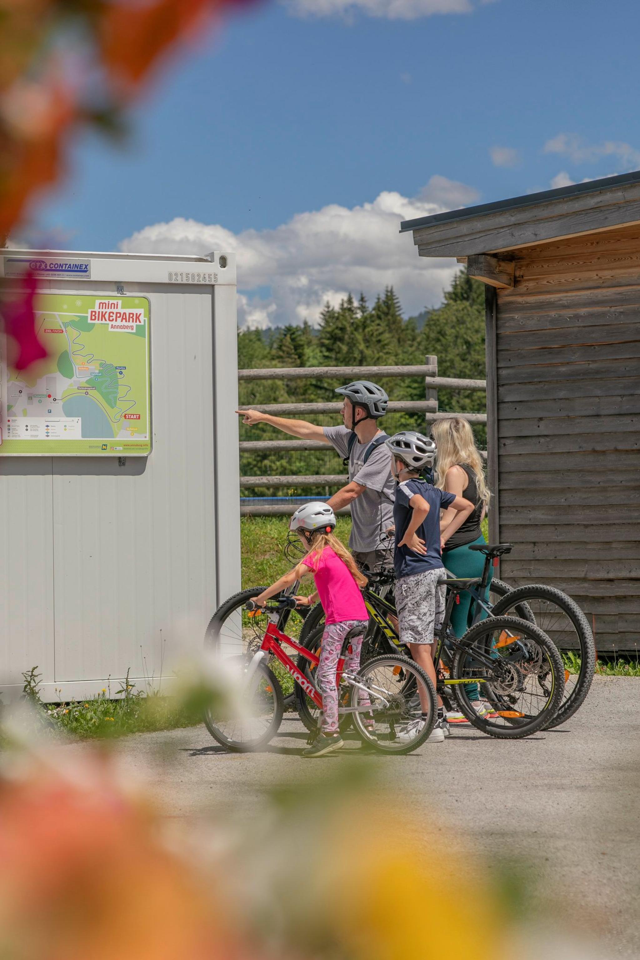 Eine Familie sieht sich den Plan des Mini-Bikeparks an