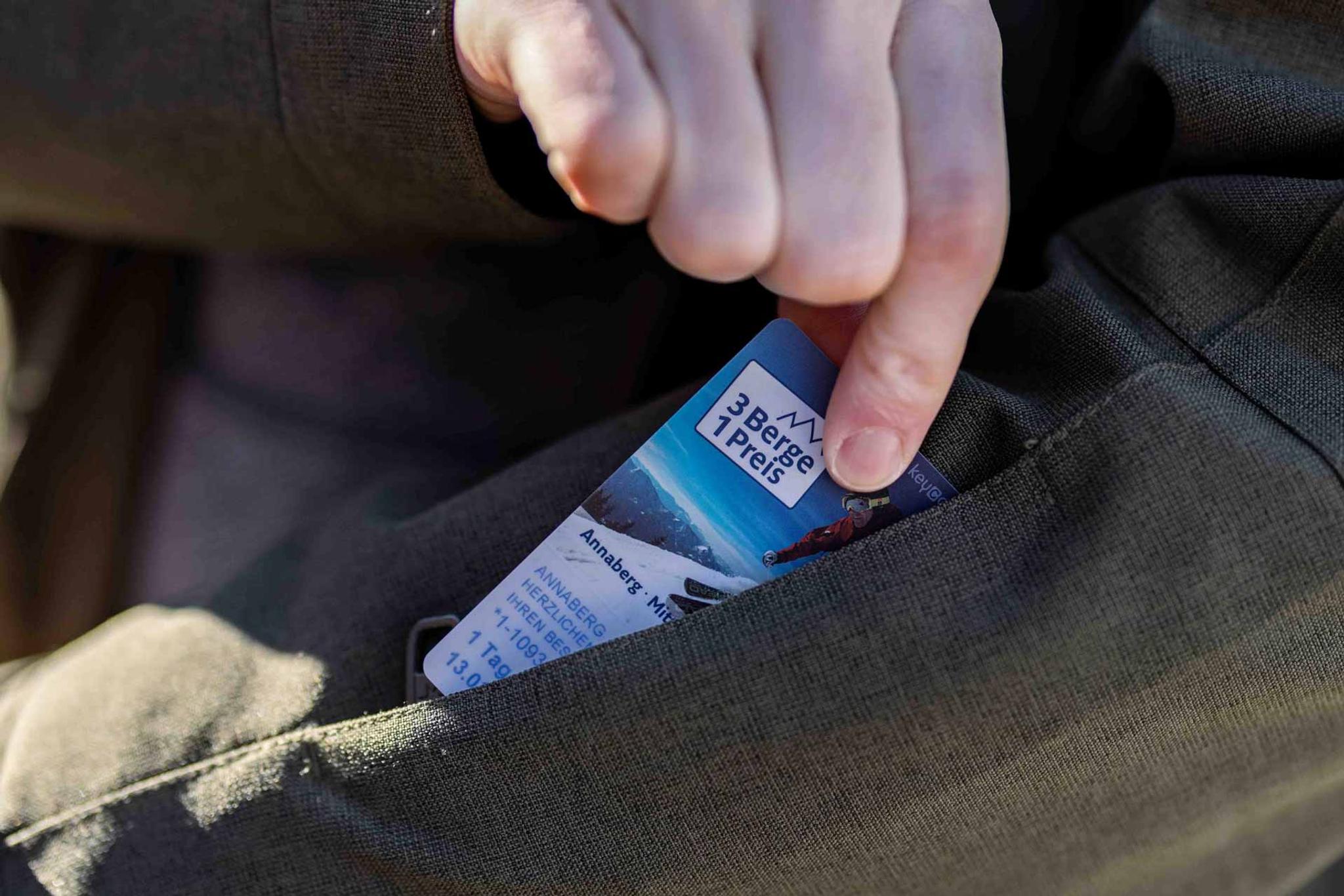 Die Keycard auf der das gültige Skiticket gebucht ist, wird aus der Jackentasche gezogen