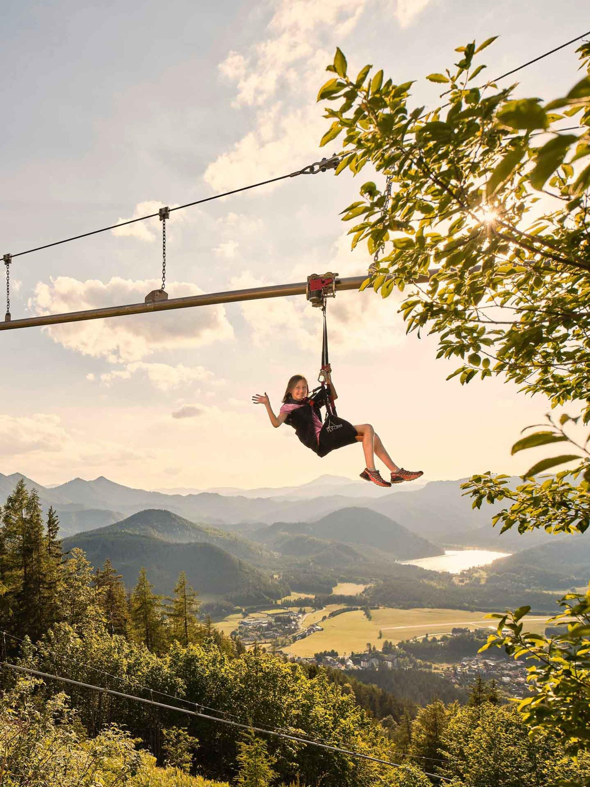 Ein Mädchen fliegt voller Freude mit der Wald8erbahn 