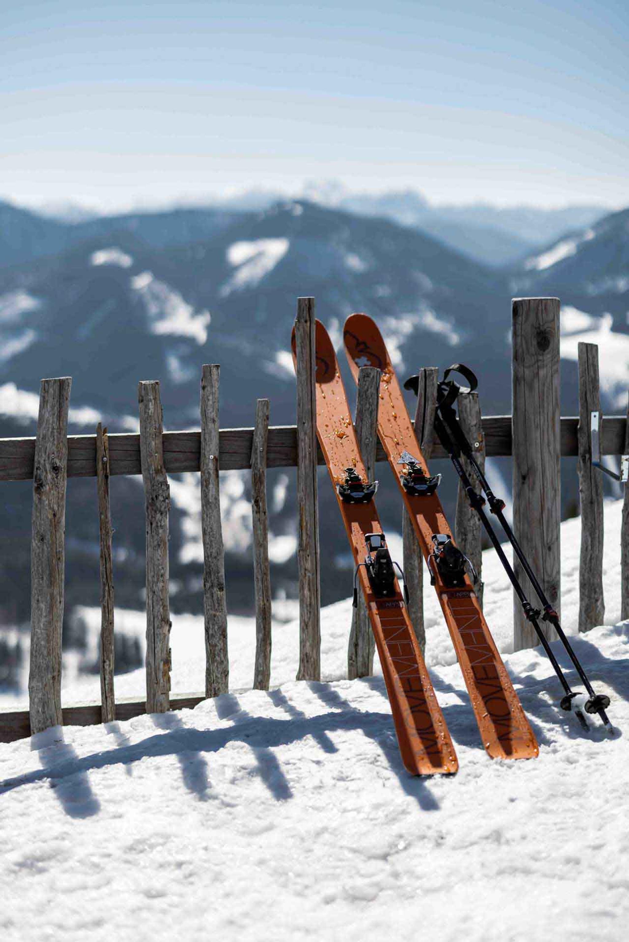 Ein paar Ski wurde im Schnee an den Zaun gelehnt
