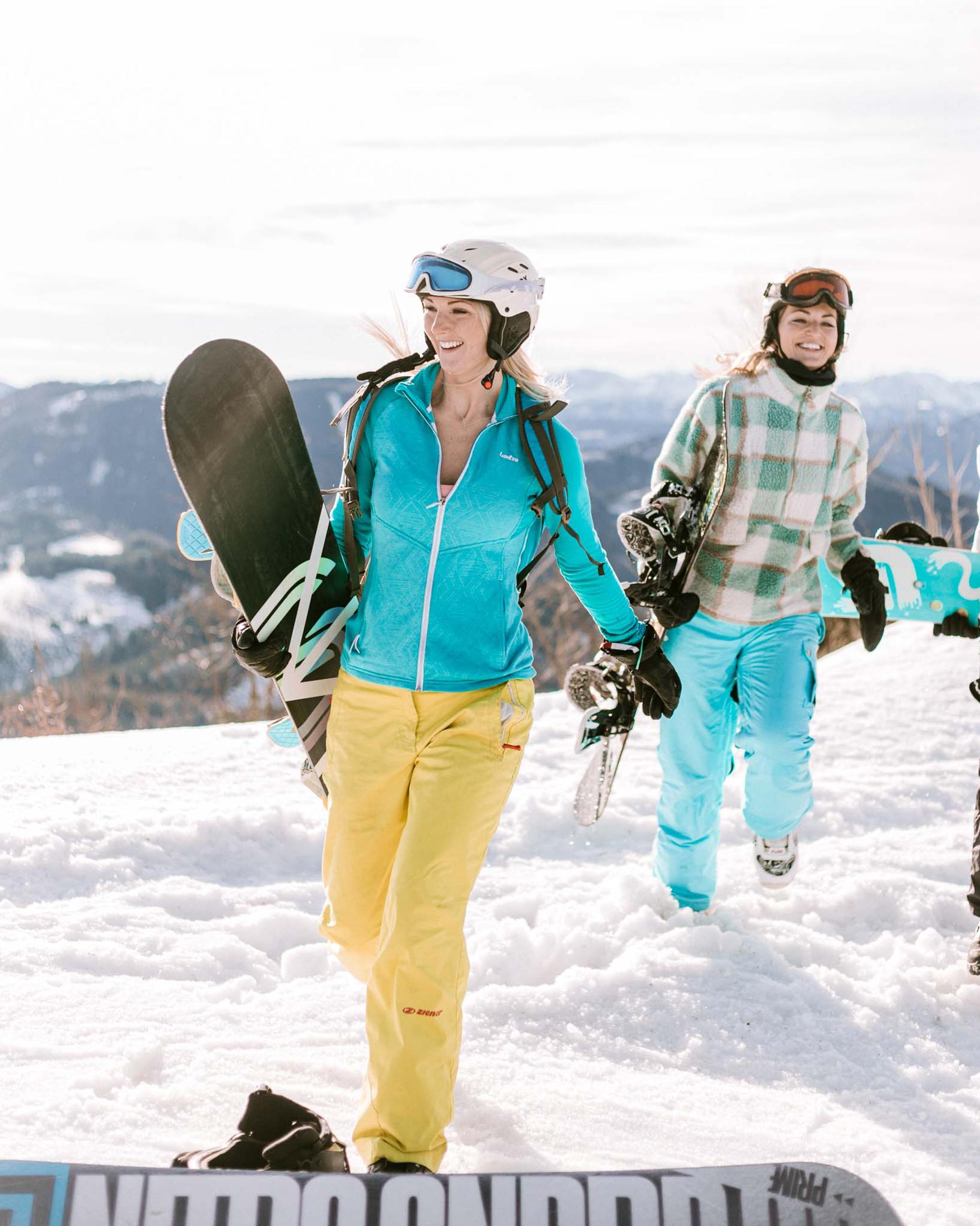 2 Snowboardfahrerinnen machen sich zur Abfahrt bereit