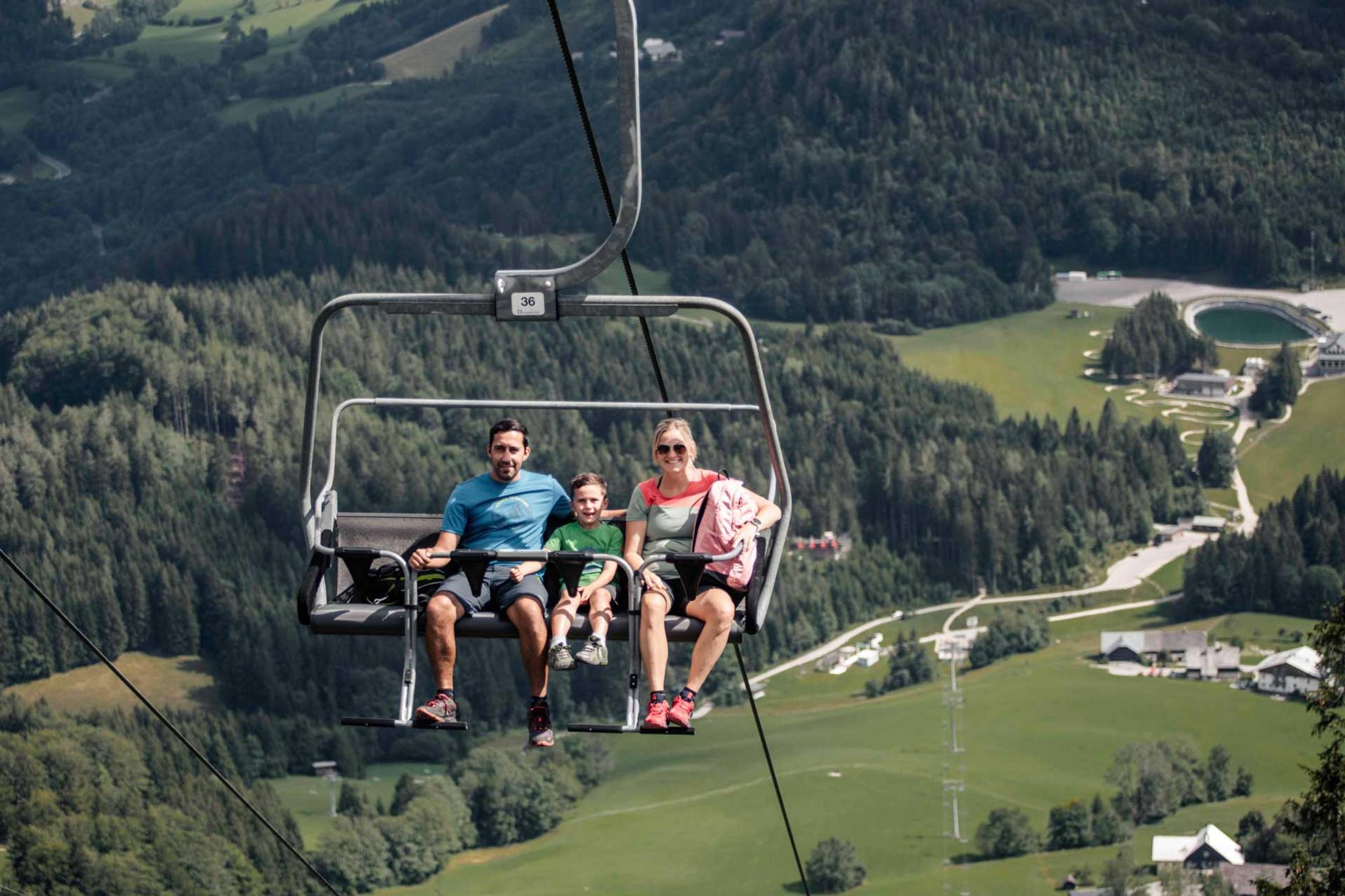Eine Familie fährt mit dem Sessellift auf das Hennesteck