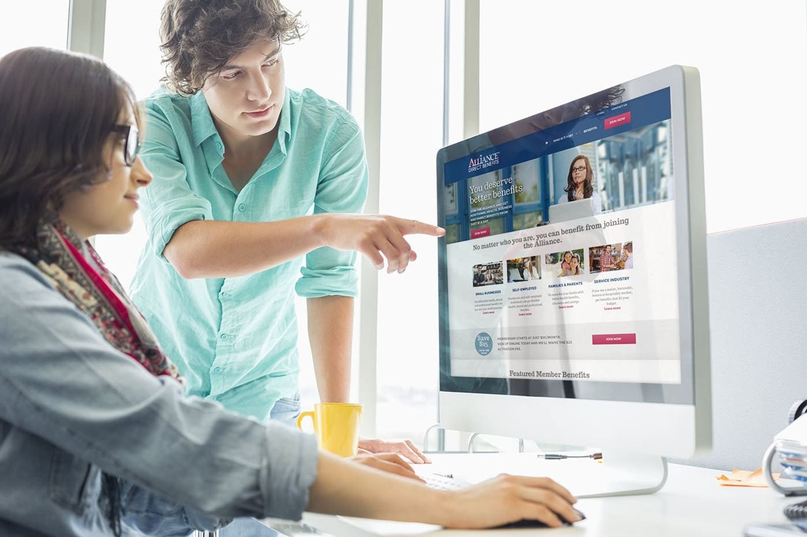 Two people reviewing the site on a desktop