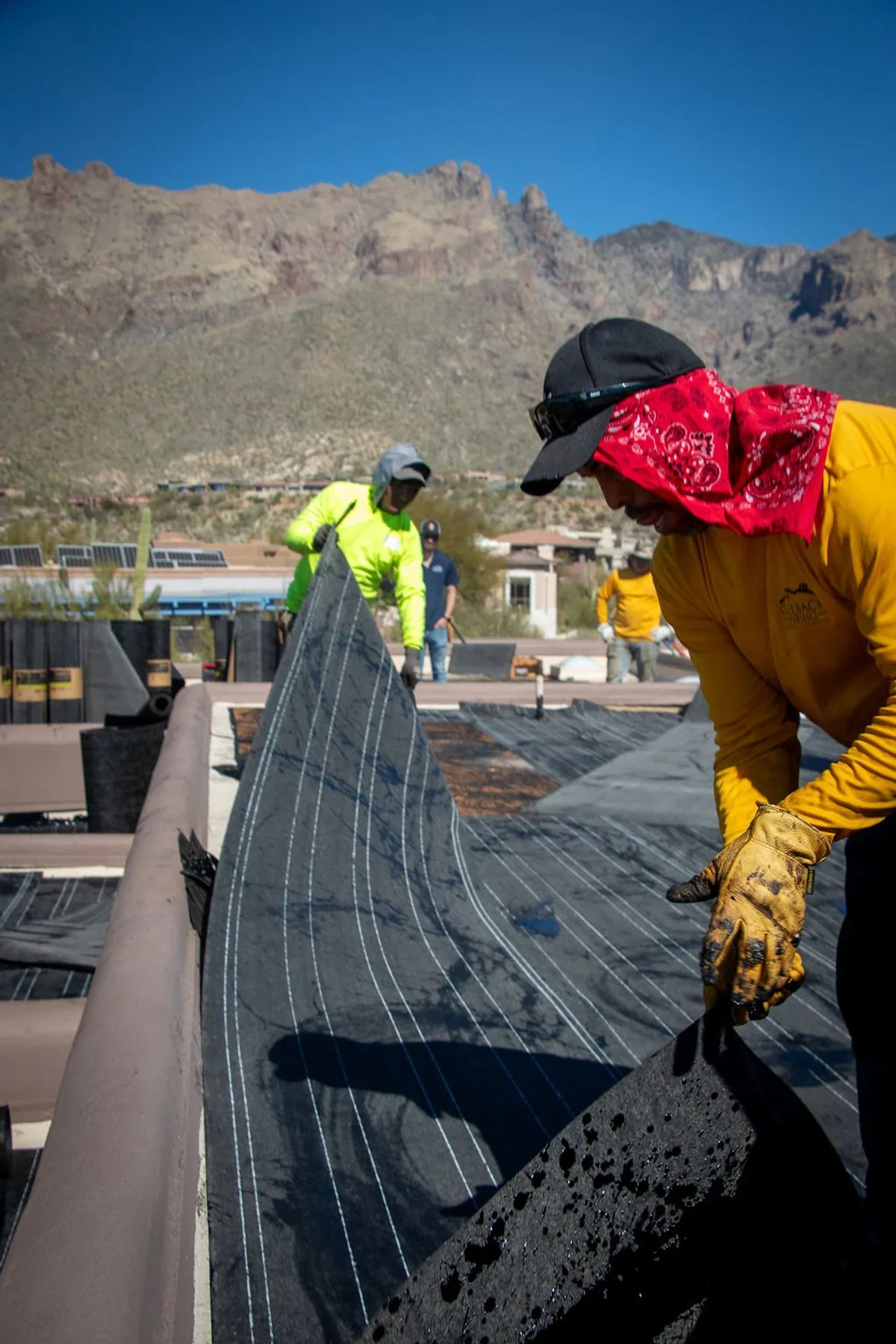 Roofer rolling out modified bitumen membrane