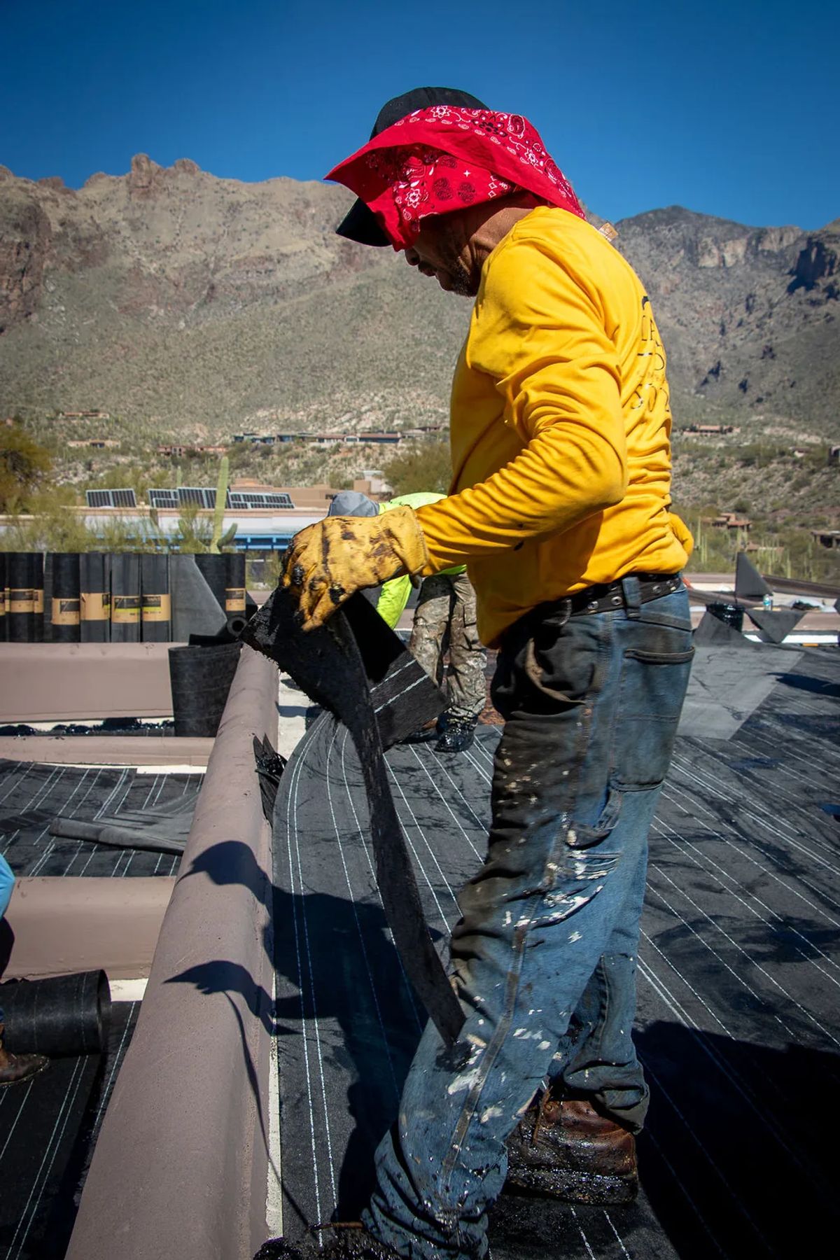 Roofer applying hot tar on a flat roof