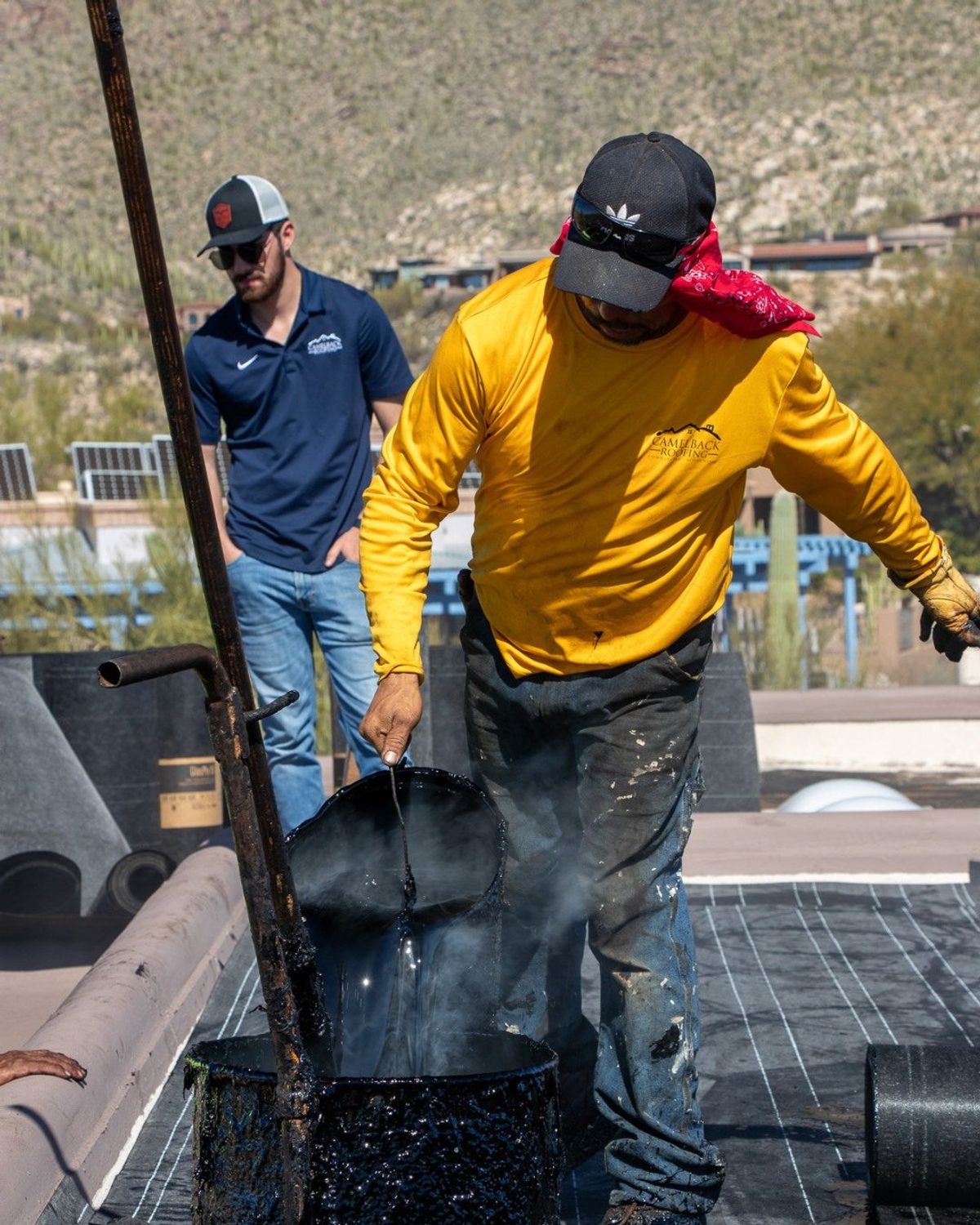 Camelback Roofing foreman supervising a hot tar pour