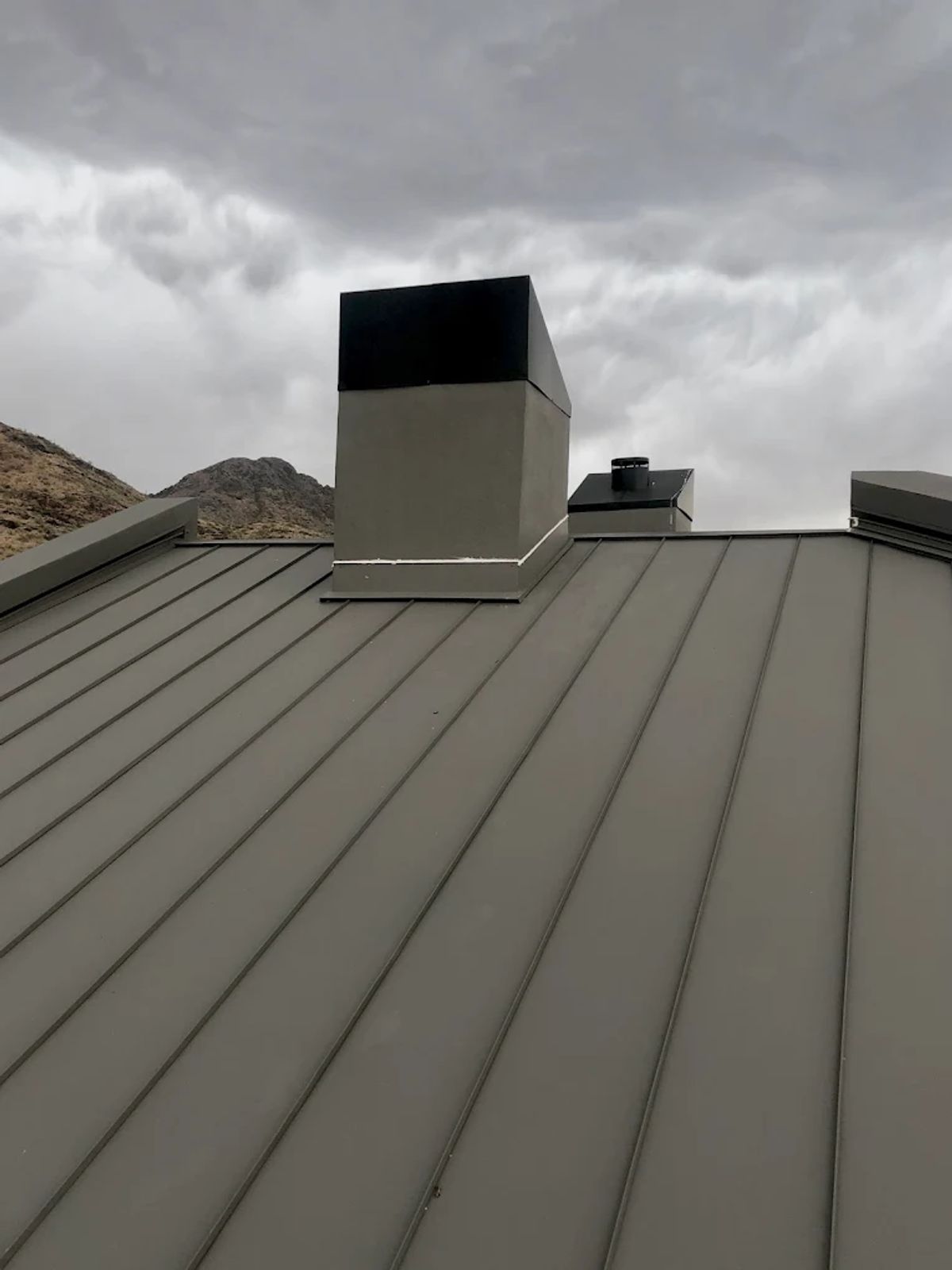 Standing seam metal roof on a home with desert mountain views