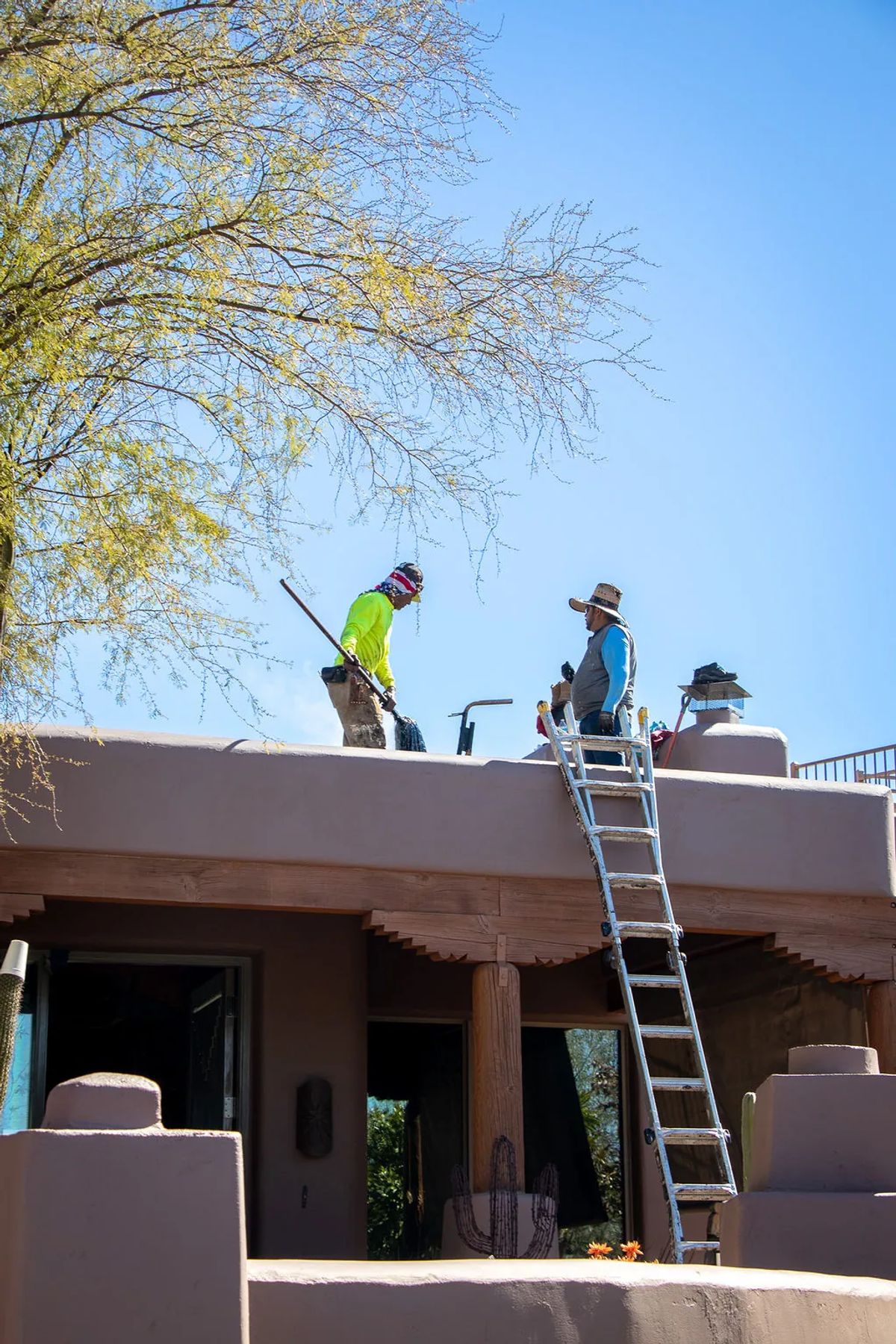 Camelback Roofing crew with ladders working on a desert home