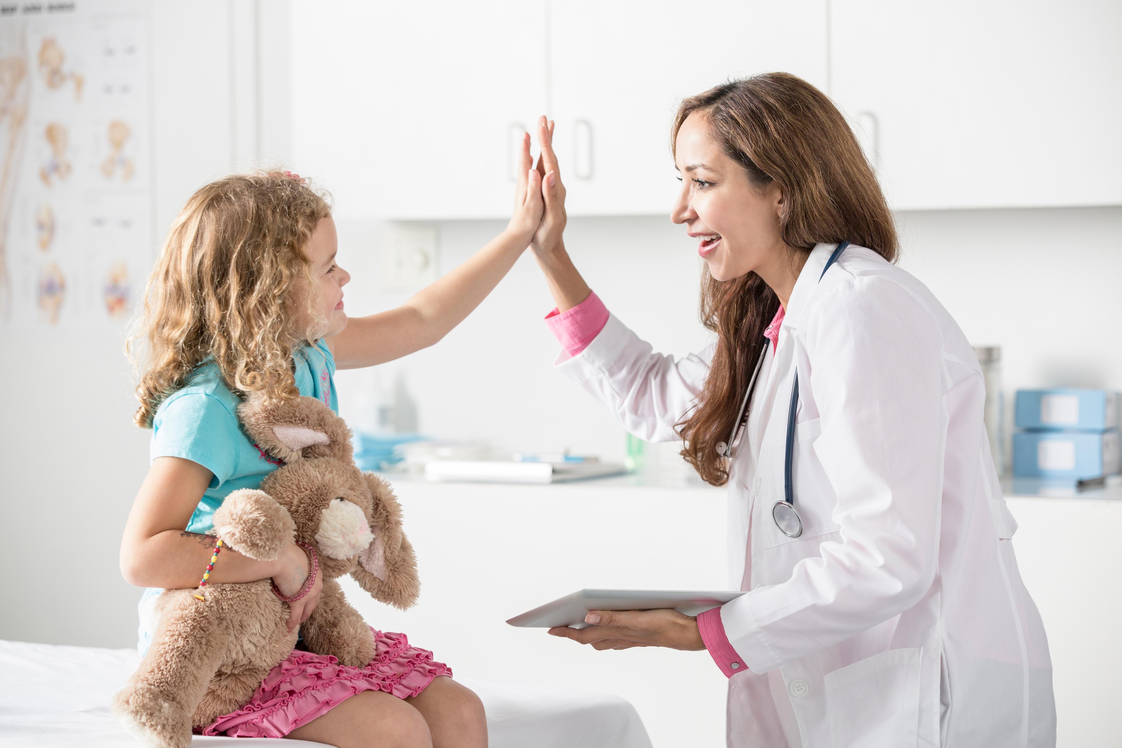 FNP vs NP - a picture of an NP high-fiving a young female patient.