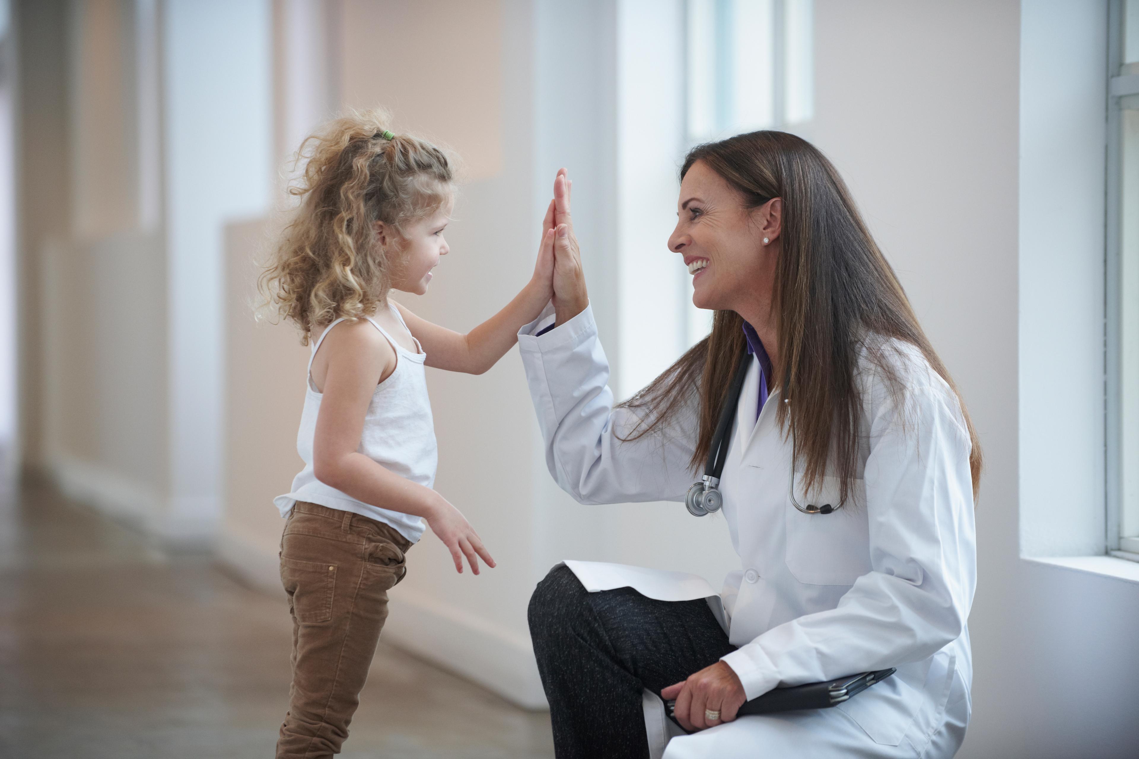 Why Nurse Practitioner? -- a picture of an NP high-fiving a young girl.