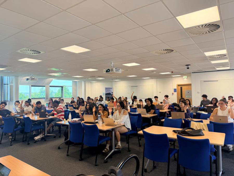 Students working on laptops during an AI Lab session at Leeds University Business School, 'Our purpose is to make a positive impact on the economy, society, and the planet' wall visible in the background