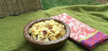 a bowl of rustic smashed potatos on top of a green blanket.