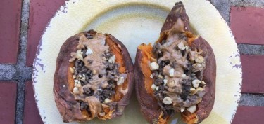 two sweet potatos cut in half filled with peanut sauce.