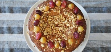 cake decorated with peanut bits and grapes.