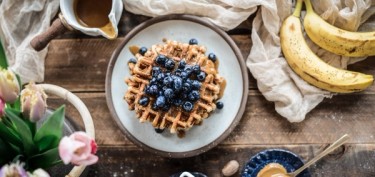 a stack of waffles with fresh blueberries on top.