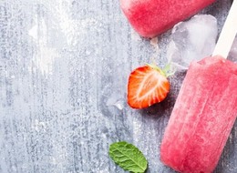 strawberries and ice cubes next to a popsicle.