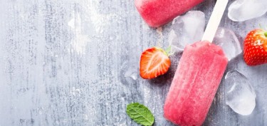 strawberries and ice cubes next to a popsicle.