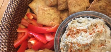 bowl of crackers and red peppers next to a dip cream.