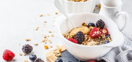 Granola and berries in a white bowl.