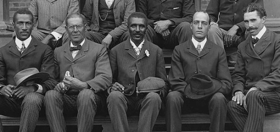 a group of men in suits and ties sitting on a bench with Carver in the middle.