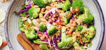 a salad with shredded red cabbage, broccoli and peanuts.