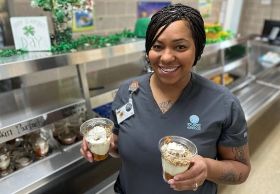 woman holding two cups of dessert made with peanuts