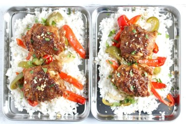 two trays filled with chicken and vegetables on top of rice.