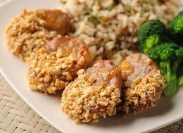 slices of pork in a plate with rice and brocolli.