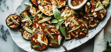 thick slices of eggplant covered in spicy sauce and peanuts bits.