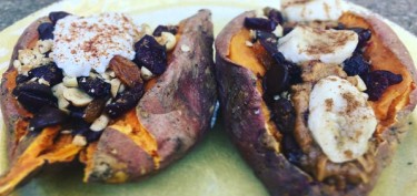 two big sweet potatos baked and cut in half stuffed with nuts and fruits.