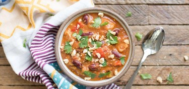 a bowl of chili with beans and cilantro.