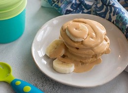 small pancakes glazed in peanut butter cream and banana slices.