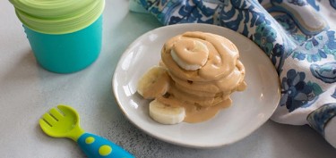 small pancakes glazed in peanut butter cream and banana slices.