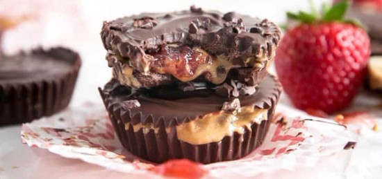 Chocolate cups filled with strawberries and peanut butter.