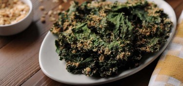 baked kale leaves coated with a peanut mixture.