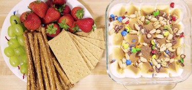 a plate of crackers and fruits with a toasted marshmallow tray on the side.