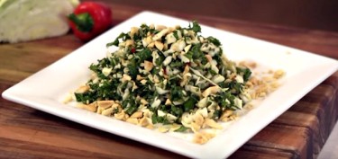 plate full of chopped kale with lots of diced peanuts.