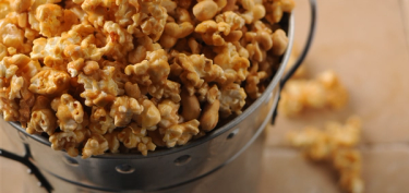 a bucket filled with caramel popcorn.