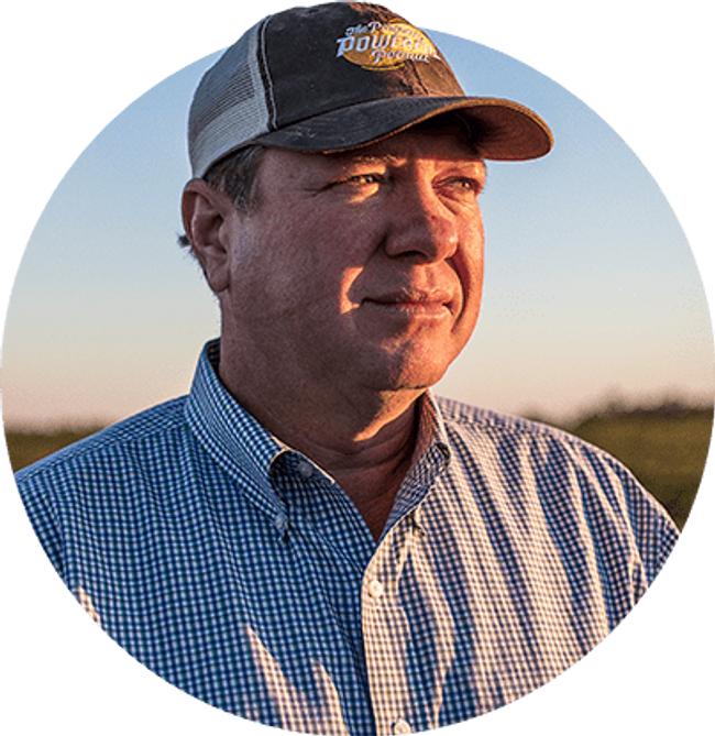 close up photo of farmer Thomas Adams in a field wearing a cap.